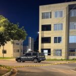 Cena de rua no Guará II com fita de isolamento policial e viatura da PMDF, representando local de crime no Distrito Federal.