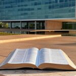 Bíblia aberta em pedestal na Câmara Legislativa de Brasília, representando elevação a patrimônio cultural ignorando diversidade.