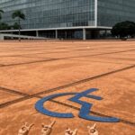 Edifício da CLDF em Brasília com símbolo de Libras abandonado, representando atraso e negligência no reconhecimento da língua de sinais.