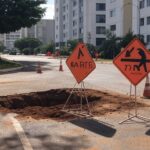 Rua na Asa Norte com sinalização de manutenção em tubulações de água, Brasília.