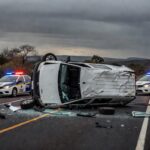 Acidente com van clandestina na BR-020, veículo tombado e viaturas policiais no local, sem pessoas.