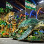 Desfile de carnaval no Sambódromo com carros alegóricos da Acadêmicos de Niterói, homenageando temas brasileiros, em ambiente festivo noturno.