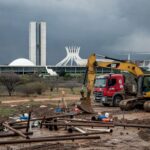 Obras de saneamento em Brasília com tubulações e equipamentos parados, destacando atrasos e riscos hídricos no DF.