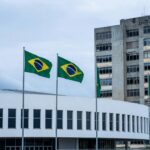 Fachada da CLDF em Brasília com hospital deteriorado ao fundo, expondo falhas crônicas no sistema de saúde do DF.