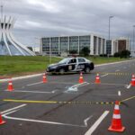 Cena de rua em Brasília com sinais de atropelamento, cones de trânsito e viatura policial, representando acidente no Distrito Federal.