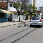 Cena de acidente com bicicleta caída e carro Toyota Etios em rua de Sobradinho, DF, Brasil.