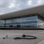 Hospital público deteriorado e viatura policial enferrujada em Brasília, ilustrando falhas na saúde e segurança do DF.