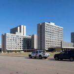 Hotéis no Setor Hoteleiro de Brasília com viaturas de polícia, representando ampliação da Área de Segurança Especial.