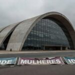 Fachada da CLDF em Brasília com elementos simbólicos de falhas em iniciativas para mulheres, idosos e saúde no DF.