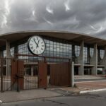 Edifício da Caesb em Brasília com portões fechados e relógio, simbolizando barreiras em vagas de estágio no DF.