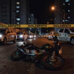 Cena de duplo homicídio em rua de Taguatinga, com fita de isolamento e viaturas da Polícia Militar do DF.