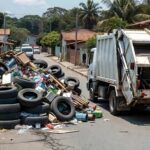 Caminhão removendo entulhos em mutirão contra dengue no Riacho Fundo II, com pilhas de resíduos em rua residencial.