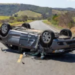Carro capotado na BR-040 em Santa Maria com ferragens na estrada